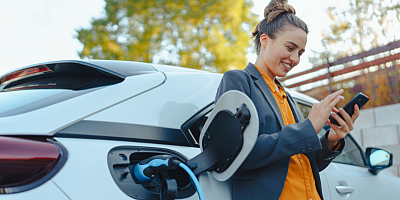 Une femme recharge une voiture électrique